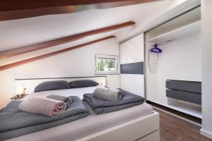 a bedroom with a large white bed with two pillows at Apartments Victoria in Dramalj
