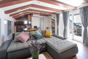 a living room with a gray couch with colorful pillows at Apartments Victoria in Dramalj