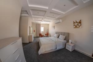 a white bedroom with a bed and a desk at The view apartment -studio 1 in Al Baha