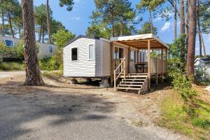a tiny house in the woods with a porch at Bungalow Cap Ferret Les Lodges 3 in Lège-Cap-Ferret