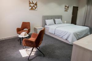 a bedroom with a bed and two chairs at The view apartment -studio 1 in Al Baha