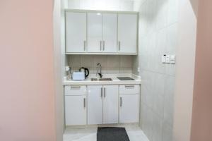 a kitchen with white cabinets and a sink at The view apartment -studio 1 in Al Baha