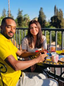 a man and a woman sitting at a table at Villa Marrakech Rouge in Aït Zat