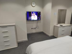 a bedroom with a bed and a tv on a wall at The view apartment -studio 1 in Al Baha