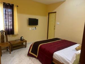 a bedroom with a bed and a tv on the wall at Kodai Cloud Villa in Kodaikānāl +83 photos