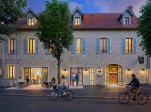 people riding bikes in front of a building at Chez Gratien Hôtel Bistro Spa in Villeneuve-dʼAveyron