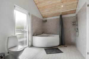 a bathroom with a tub and a toilet and a window at C11323-Tarm-Brombaervej-8 in Tarm +27 photos
