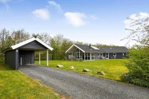 a house with a gravel driveway next to a house at C11323-Tarm-Brombaervej-8 in Tarm