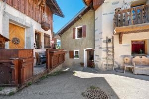 a building with a gate and a chair in a courtyard at Chalet Le Hameau Tranquille in Courchevel