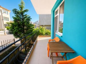 a balcony with a wooden table and orange chairs at Kazlarov Guest House in Kiten