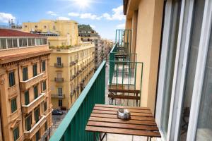 a wooden bench on a balcony with a view of a city at Maxim in Palermo