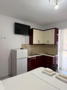 a kitchen with red cabinets and a white refrigerator at Vila Ani in Ksamil +51 photos