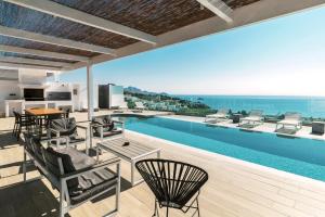 a large swimming pool with chairs and a table at Cavo Lindos Villas in Lindos