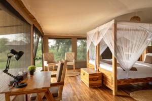 a bedroom with a bed with mosquito net at Manya Luxury Camp in Serengeti