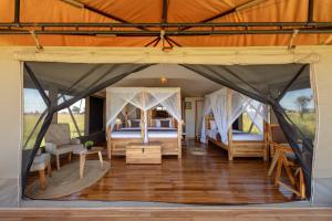 a large tent with two beds in a room at Manya Luxury Camp in Serengeti