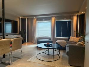 a living room with a couch and a table at Villa Nyheim in Florø +6 photos