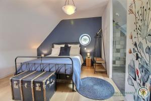 a bedroom with a bed with a blue wall at La métairie in Plédèliac