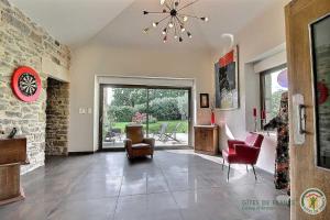 a living room with chairs and a stone wall at La métairie in Plédèliac