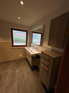 a bathroom with a sink and a mirror at Chalet Lilly inkl. Chiemgaukarte in Ruhpolding +20 photos