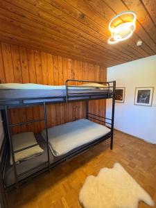 two bunk beds in a room with a wooden ceiling at Chalet Lilly inkl. Chiemgaukarte in Ruhpolding