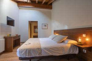 a bedroom with a large bed with a wooden headboard at La Posada del Vencejo in Alles
