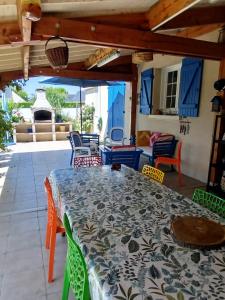a patio with a table and chairs on a patio at maison fleurie in Longué