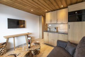 a living room with a table and a kitchen at Résidence La Forêt Du Praz - Courchevel 1850 in Courchevel +6 photos