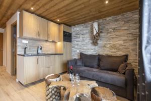 a living room with a couch and a table at Résidence La Forêt Du Praz - Courchevel 1850 in Courchevel