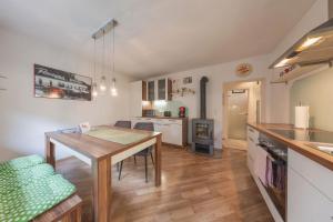 a kitchen and dining room with a wooden table at Stubai Apartment Telfes in Telfes im Stubai