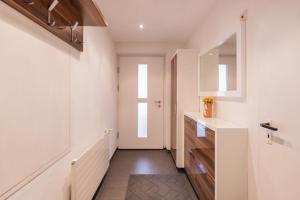a hallway with a sink and a mirror at Stubai Apartment Telfes in Telfes im Stubai +52 photos