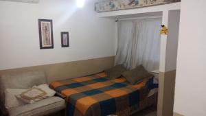 una camera da letto con un letto, una sedia e una finestra di Alojamiento Cba Observatorio a Córdoba