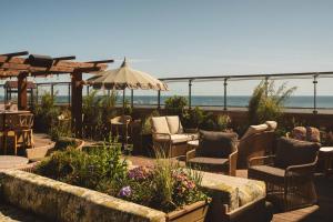 a patio with chairs and an umbrella and the ocean at Rox Resort in Køge