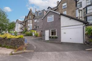 a house with a white garage in the street at Lonsdale House in Bowness-on-Windermere