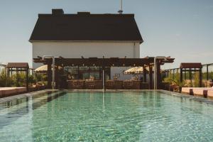 a swimming pool with a restaurant in the background at Rox Resort in Køge