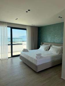 a bedroom with a bed with a view of the beach at ReiVal Hotel Marina Vlore in Vlorë