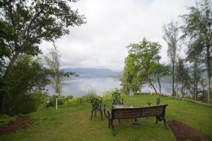 a bench on a hill with a view of a lake at White Castle in Malavli +1 photo