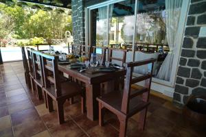 a wooden table and chairs in a room with a window at White Castle in Malavli