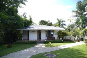 a small white house with a grass yard at White Castle in Malavli