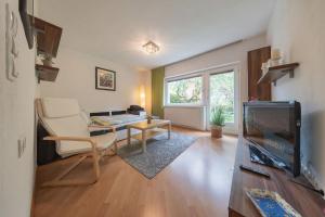 a living room with a couch and a tv at Stubai Apartment Telfes in Telfes im Stubai