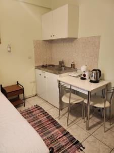 a kitchen with a table and chairs in a room at MSK Studios in Nydri