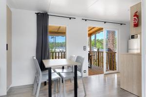 a kitchen and dining room with a table and chairs at Bungalow Cap Ferret Les Lodges 2 in Lège-Cap-Ferret +15 photos