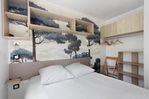 a bedroom with a bed and a painting on the wall at Bungalow Cap Ferret Les Lodges 2 in Lège-Cap-Ferret