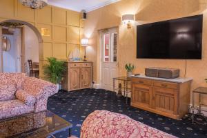 a living room with a couch and a flat screen tv at Lonsdale House in Bowness-on-Windermere