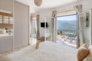 a bedroom with a bed and a balcony with a view at Douce Heure & Saveurs in Tavaco