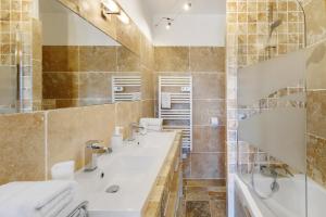 a bathroom with two sinks and a tub and a shower at Douce Heure & Saveurs in Tavaco +21 photos