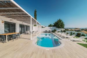 a patio with a table and chairs and a swimming pool at Cavo Lindos Villas in Lindos +34 photos