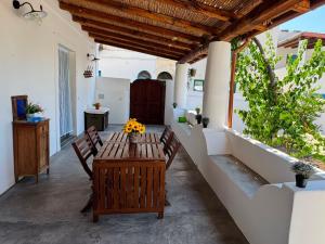 a patio with a wooden table and chairs at Appartamenti Alba&Tramonto in Stromboli +16 photos