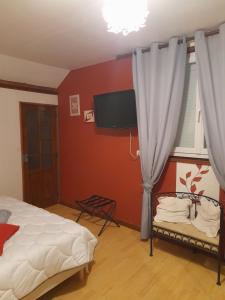 ein Schlafzimmer mit Bett und Flachbildfernseher in der Unterkunft Chambre d'hôte 4 personnes in Magnien