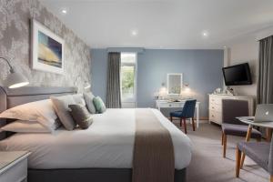 a hotel room with a large bed and a desk at Budock Vean Hotel and Spa in Falmouth