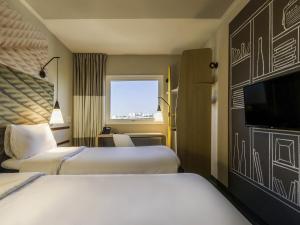 a hotel room with two beds and a flat screen tv at Ibis Americana in Americana +37 photos